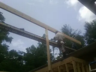 Carpenter setting a ridge beam over a new addition frame — Ice Dam Removal by Roofing Brothers in Showell