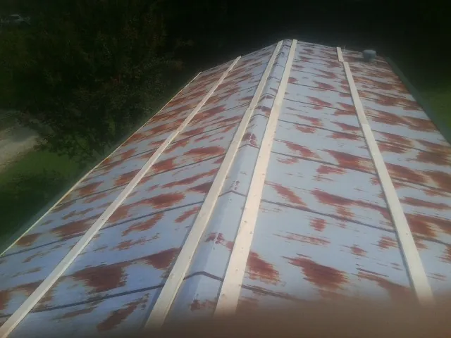 Rusted metal roof panels with new wood purlins before replacement — Storm Damage Roof Repair in Showell by Roofing Brothers