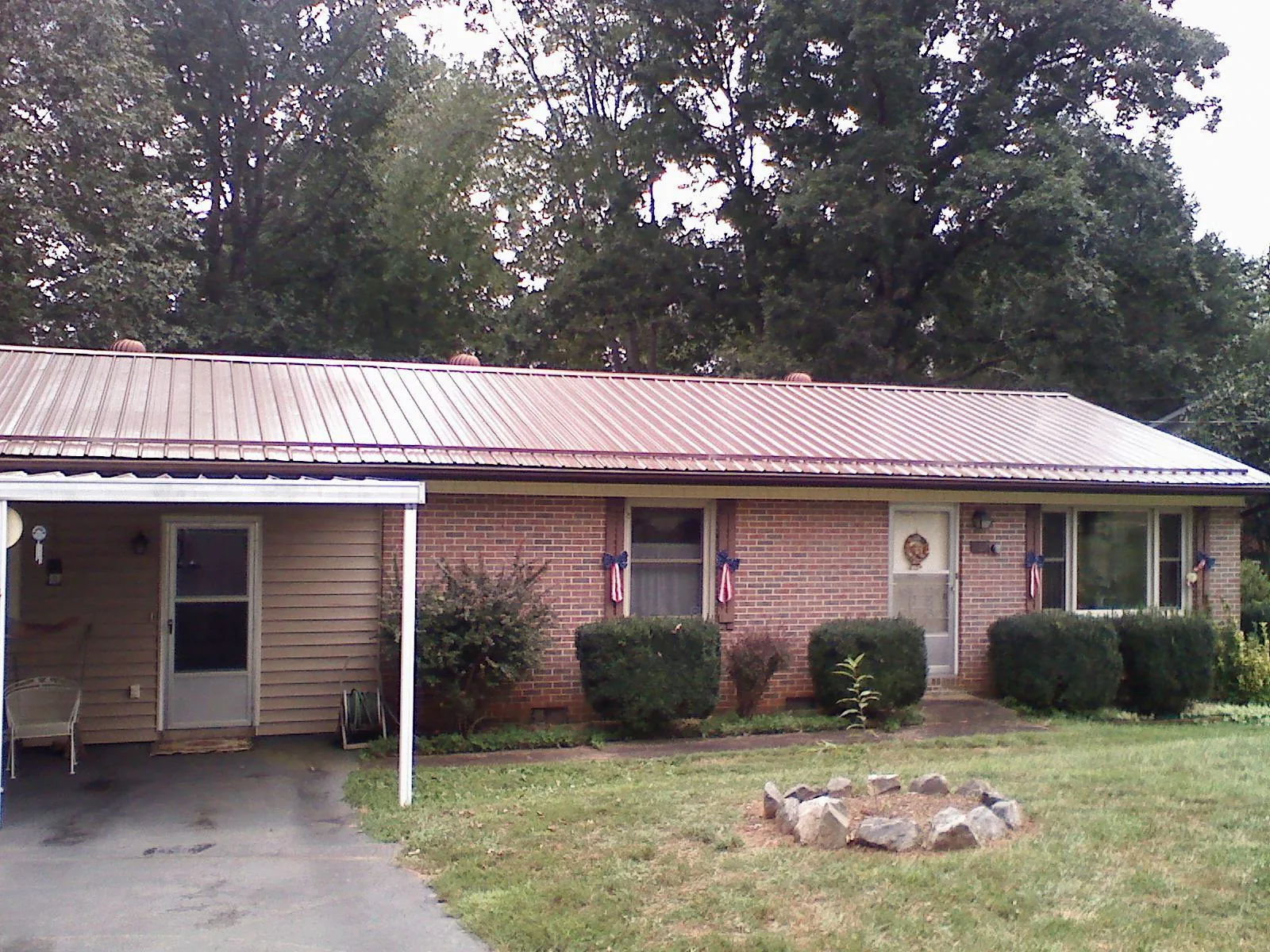 Bronze metal roof and carport on a brick ranch home — Roof Repair work by our crew in Showell